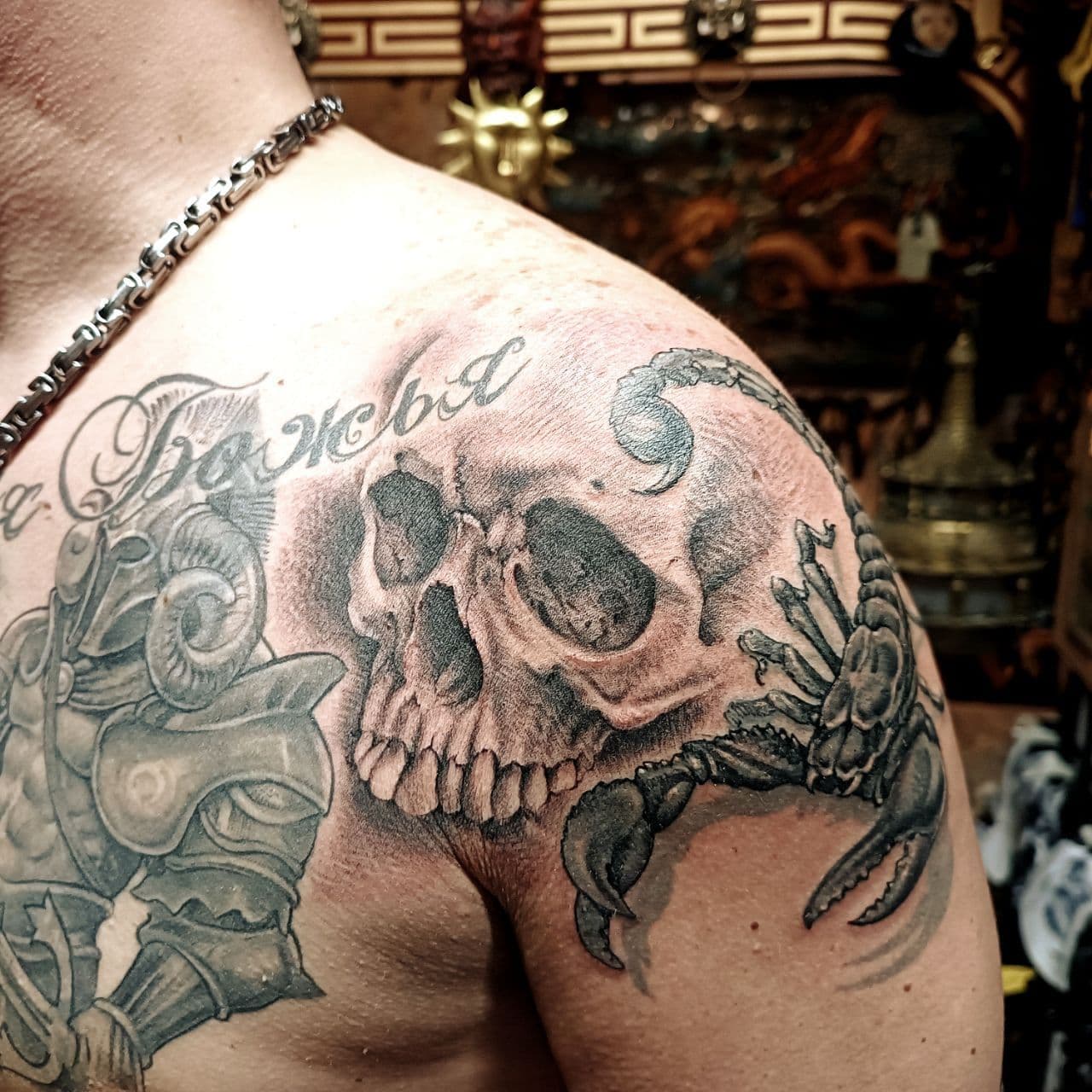 Black-and-grey tattoo – weathered skull with two ravens on the forearm